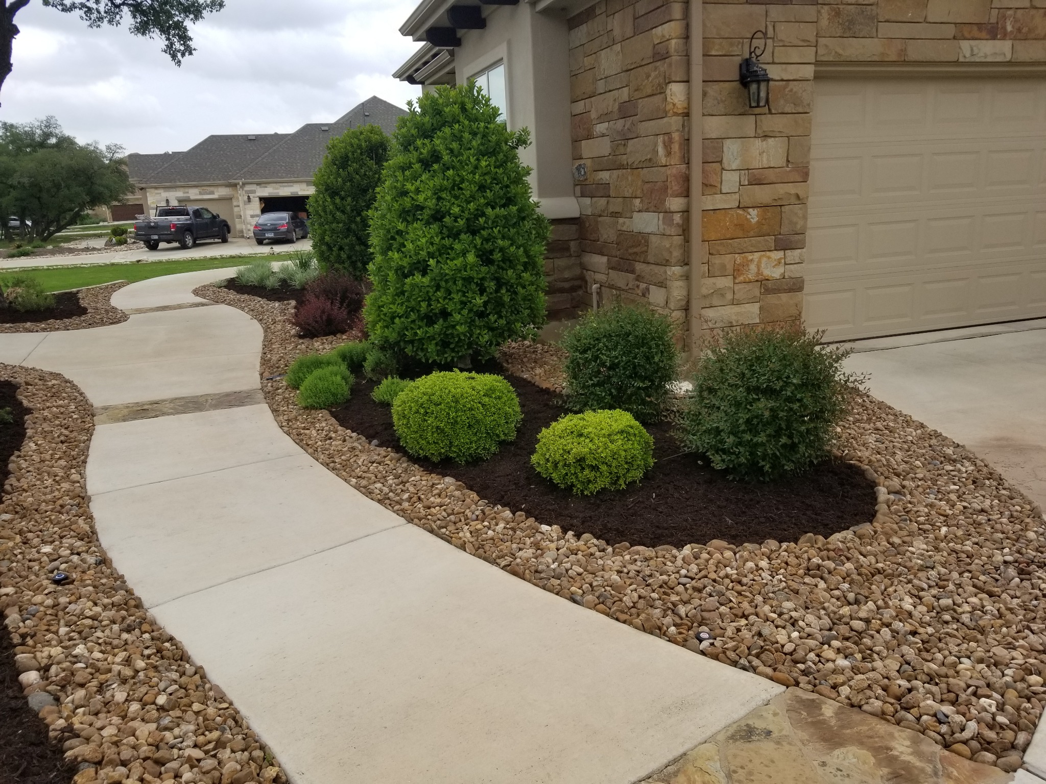 Fresh dark mulch around shrubs and a walkway at a Georgetown home