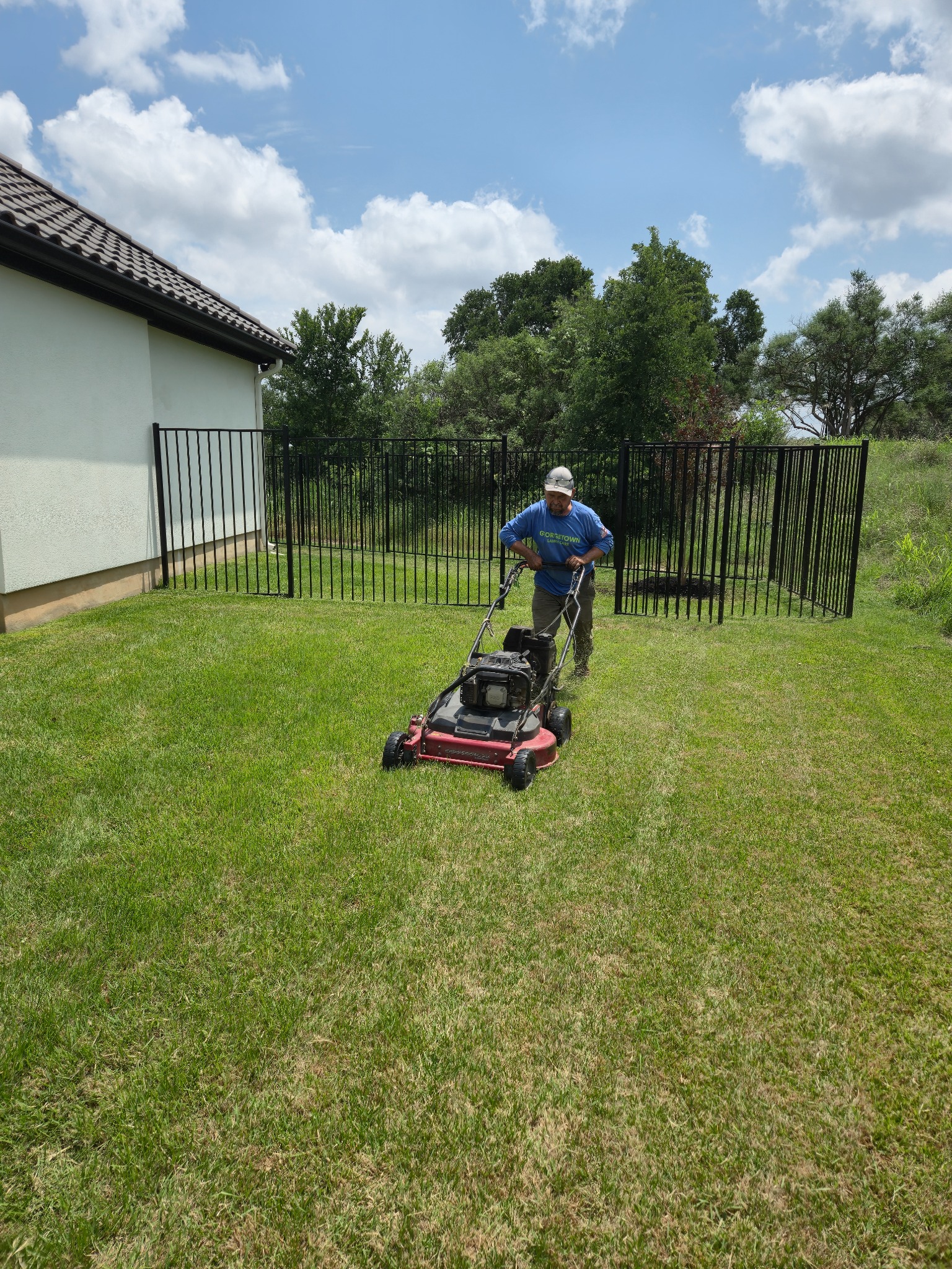 Georgetown Lawn Care team member mowing a lawn